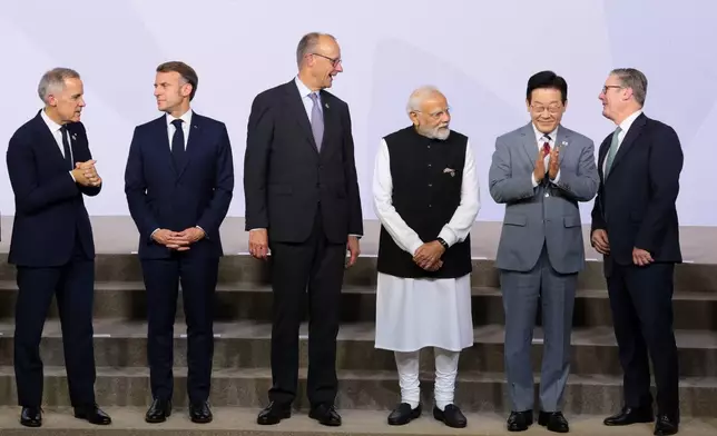 From left, Canada's Prime Minister Mark Carney, France's President Emmanuel Macron, Germany's Chancellor Friedrich Merz, India's Prime Minister Narendra Modi, South Korea's President Lee Jae Myung, and British Prime Minister Keir Starmer stand as leaders pose for a group photo, on the opening day of the G20 Leaders' Summit, in Johannesburg, South Africa, Saturday, Nov. 22, 2025. (Yves Herman/Pool Photo via AP)