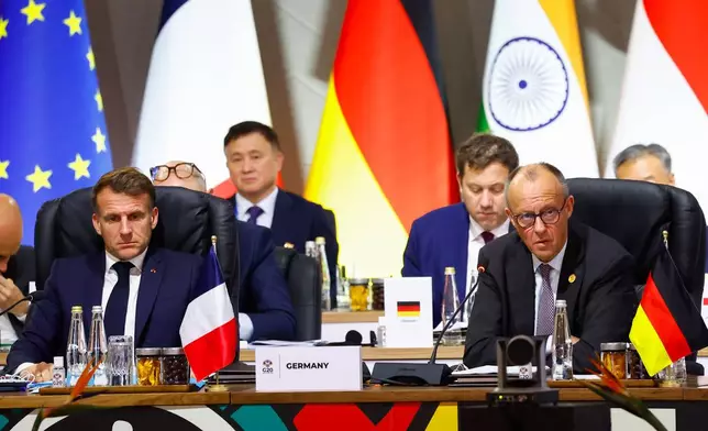 France's President Emmanuel Macron and Germany's Chancellor Friedrich Merz attend a plenary session on the opening day of the G20 Summit at the Nasrec Expo Centre, in Johannesburg, South Africa, Saturday, Nov. 22, 2025. (Thomas Mukoya/Pool Photo via AP)