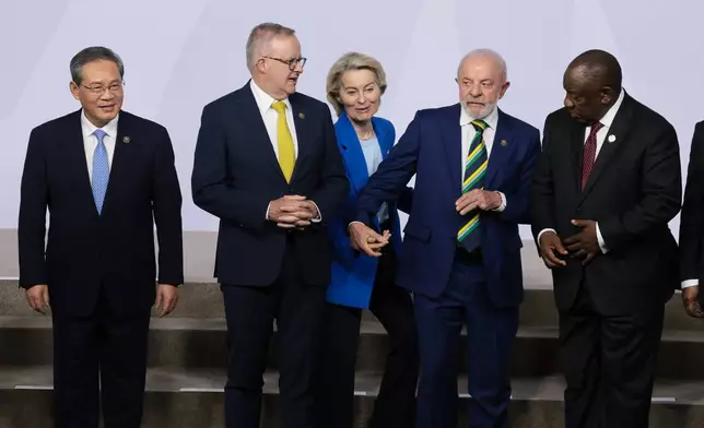 European Commission President Ursula von der Leyen, center, reacts next to Brazil's President Luiz Inacio Lula da Silva, Australia's Prime Minister Anthony Albanese, Chinese Premier Li Qiang, and South Africa's President Cyril Ramaphosa as leaders pose for a group photo, on the opening day of the G20 Leaders' Summit, in Johannesburg, South Africa, Saturday, Nov. 22, 2025. (Yves Herman/Pool Photo via AP)