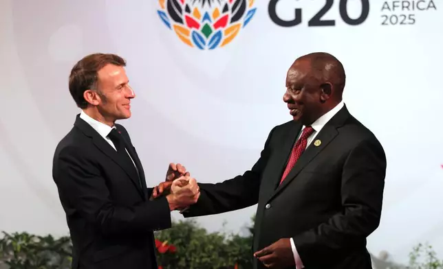 South African Cyril Ramaphosa, right, welcomes welcomes French President Emmanuel Macron, on the opening day of the G20 Summit, in Johannesburg, South Africa, Saturday, Nov. 22, 2025. (Halden Krog/Pool Photo via AP)