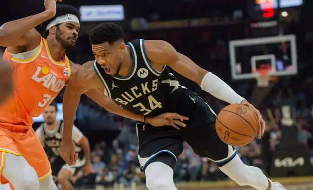 Milwaukee Bucks' Giannis Antetokounmpo (34) drives against Cleveland Cavaliers' Jarrett Allen during the first half of an NBA basketball game in Cleveland, Monday, Nov. 17, 2025. (AP Photo/Phil Long)