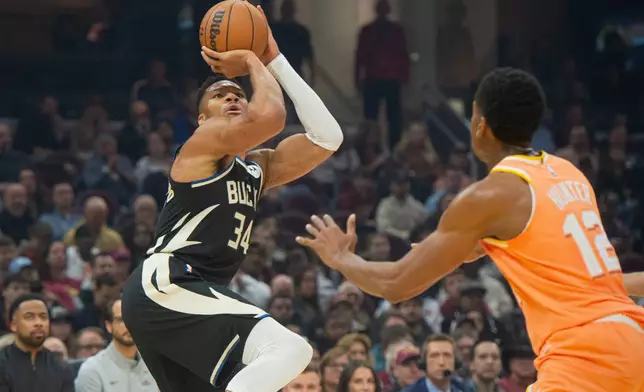 Milwaukee Bucks' Giannis Antetokounmpo (34) shoots as Cleveland Cavaliers' De'Andre Hunter (12) defends during the first half of an NBA basketball game in Cleveland, Monday, Nov. 17, 2025. (AP Photo/Phil Long)