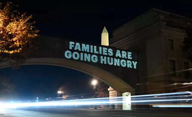 A message from the National Women's Law Center concerning the announcement by the Trump administration of restoring only half funding the SNAP benefits is projected on the U.S. Department of Agriculture building, Monday, Nov. 3, 2025, in Washington. (AP Photo/John McDonnell)