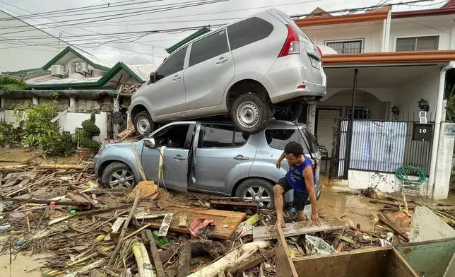 Vehicles lie piled on after flooding caused by Typhoon Kalmaegi in Cebu city, central Philippines, Tuesday, Nov. 4, 2025. (AP Photo/Jacqueline Hernandez)