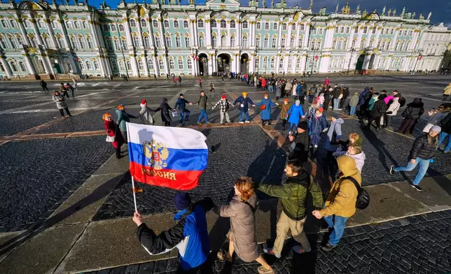 People dance in a circle marking National Unity Day at the Palace Square in St. Petersburg, Russia, Tuesday, Nov. 4, 2025. (AP Photo/Dmitri Lovetsky)