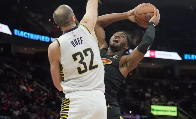 Cleveland Cavaliers guard Donovan Mitchell, right, looks to shoot as Indiana Pacers center Jay Huff (32) defends in the second half of an NBA Cup basketball game Friday, Nov. 21, 2025, in Cleveland. (AP Photo/Sue Ogrocki)