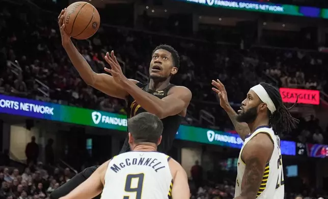 Cleveland Cavaliers forward De'Andre Hunter, top, goes to the basket between Indiana Pacers guard T.J. McConnell (9) and forward Isaiah Jackson, right, in the second half of an NBA Cup basketball game Friday, Nov. 21, 2025, in Cleveland. (AP Photo/Sue Ogrocki)