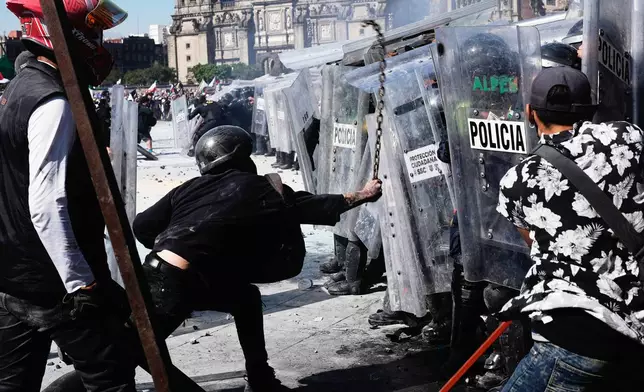 Protesters charge against police during a youth anti-government march in Mexico City, Saturday, Nov. 15, 2025. (AP Photo/Marco Ugarte)