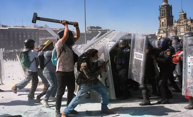 Protesters charge at police during a youth anti-government march in Mexico City, Saturday, Nov. 15, 2025. (AP Photo/Marco Ugarte)