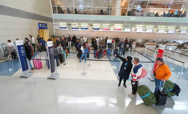Travelers check in for flights at Terminal D of Dallas Forth Worth International Airport Friday, Nov. 7, 2025, in Grapevine, Texas. (AP Photo/Julio Cortez)