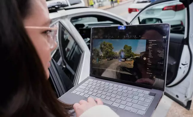 Chelsea Palacio, public information manager for the City of San Jose, showcases how a small detection camera uses AI to detect road hazards and potholes, in San Jose, Calif., Wednesday, Nov. 12, 2025. (AP Photo/Godofredo A. Vásquez)