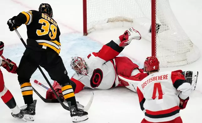 Carolina Hurricanes goaltender Pyotr Kochetkov (52) drops to the ice for the save against Boston Bruins center Morgan Geekie (39) during the first period of an NHL hockey game, Monday, Nov. 17, 2025, in Boston. (AP Photo/Charles Krupa)