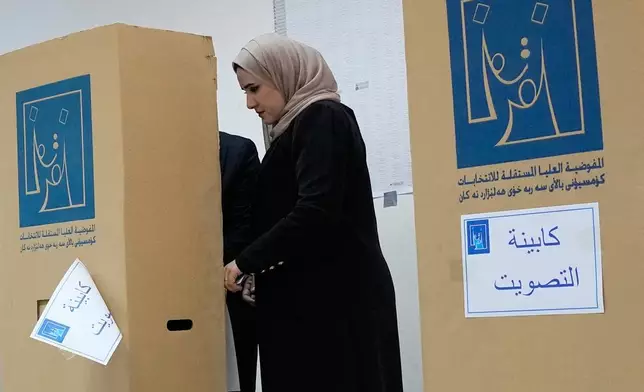 An Iraqi woman casts her vote during the parliamentary election at a polling center in Baghdad, Iraq, Tuesday, Nov. 11, 2025. (AP Photo/Hadi Mizban)