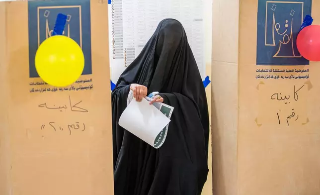 An Iraqi woman casts her vote in the country's parliamentary election at a polling center in Najaf, Iraq, Tuesday, Nov. 11, 2025. (AP Photo/Anmar Khalil)