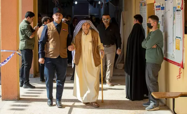 Iraqi voters gather to cast their vote at a ballot station in the country's parliamentary election in Najaf, Iraq, Tuesday, Nov. 11, 2025. (AP Photo/Anmar Khalil)