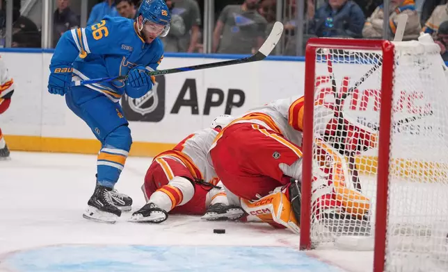 St. Louis Blues' Nathan Walker (26) eyes a loose puck before scoring during the second period of an NHL hockey game against the Calgary Flames Tuesday, Nov. 11, 2025, in St. Louis. (AP Photo/Jeff Roberson)