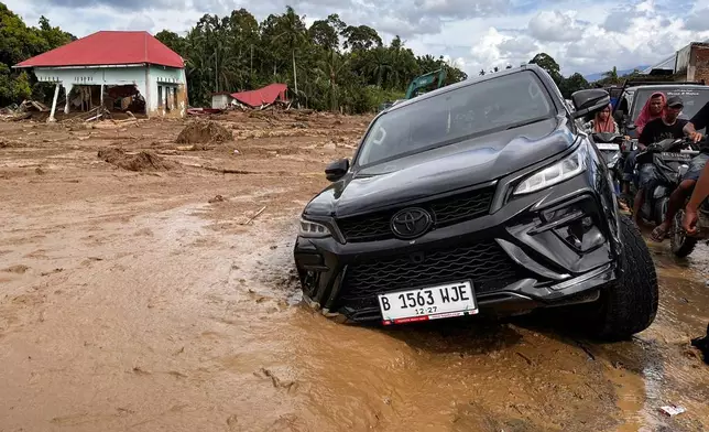 A car stuck in the mud at a village affected by flash flooding, in Agam, West Sumatra, Indonesia, Sunday, Nov. 30, 2025. (AP Photo/Ade Yuandha)