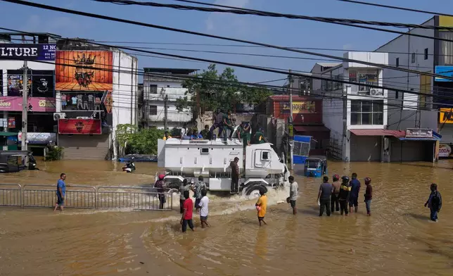 A military vehicle carries flood victims through a submerged area to safety in Colombo, Sri Lanka, Sunday, Nov. 30, 2025. (AP Photo/Eranga Jayawardena)