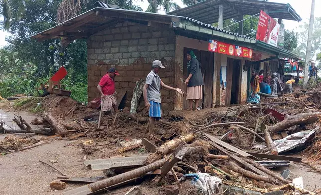 Landslide survivors clean the debris in Hanguranketha, Sri Lanka, Saturday, Nov. 29, 2025. (AP Photo/Lakshmen Neelawathura)