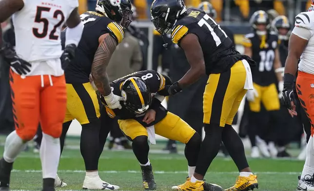 Pittsburgh Steelers quarterback Aaron Rodgers (8) is helped up off the field after a hit by the Cincinnati Bengals during the first half of an NFL football game Sunday, Nov. 16, 2025, in Pittsburgh. (AP Photo/Matt Freed)