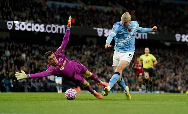 Manchester City's Erling Haaland scores his side's second goal past Bournemouth's goalkeeper Dorde Petrovic during the English Premier League soccer match between Manchester City and Bournemouth in Manchester, England, Sunday, Nov. 2, 2025. (Martin Rickett/PA via AP)