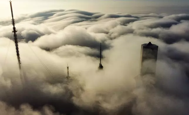 Buildings look out of the fog on top of the Feldberg mountain near Frankfurt, Germany, Monday, Nov. 10, 2025. (AP Photo/Michael Probst)