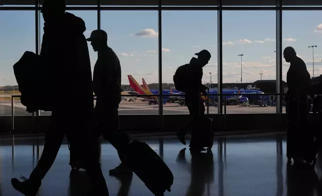 Southwest Airlines planes sit at gates as travelers walk through Baltimore/Washington International Thurgood Marshall Airport in Baltimore, Monday, Nov. 10, 2025. (AP Photo/Stephanie Scarbrough)