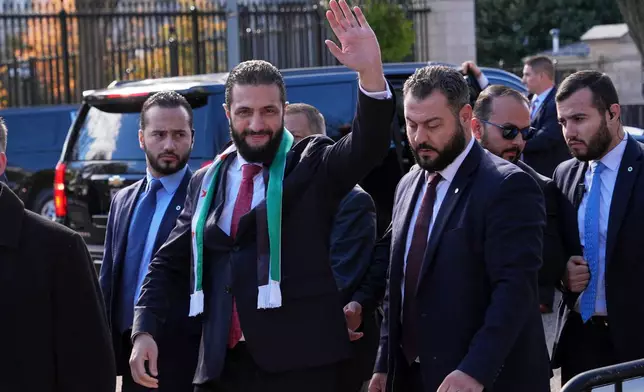 Syria's President Ahmed al-Sharaa waves as he greets supporters outside of the White House, Monday, Nov. 10, 2025, in Washington, following a meeting with President Donald Trump. (AP Photo/Jacquelyn Martin)