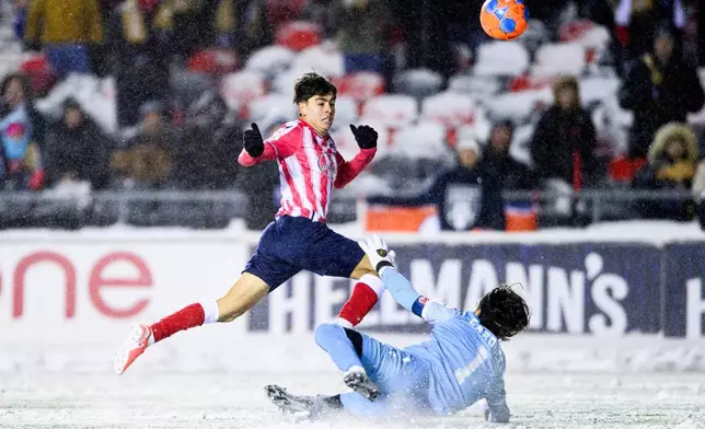 Atletico Ottawa's David Rodríguez (7) scores on Cavalry FC's Ali Musse (7) during extra time Canadian Premier League finals soccer action in Ottawa, on Sunday, Nov. 9, 2025. (Spencer Colby/The Canadian Press via AP)