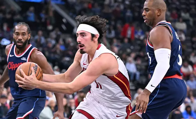 Miami Heat guard Jaime Jaquez Jr. drives past Los Angeles Clippers guard Chris Paul, right, during the first half of an NBA basketball game Monday, Nov. 3, 2025, in Los Angeles. (AP Photo/Wally Skalij)