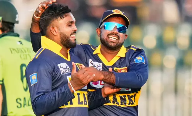 Sri Lanka's Wanindu Hasaranga, left, celebrates with teammate after the dismissal of Pakistan's Babar Azam during the first one day international cricket match between Pakistan and Sri Lanka, in Rawalpindi, Pakistan, Tuesday, Nov. 11, 2025. (AP Photo/Anjum Naveed)