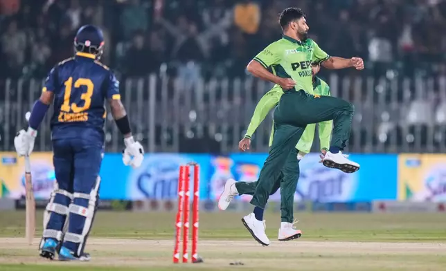 Pakistan's Haris Rauf, right, celebrates after taking the wicket of Sri Lanka's Kusal Mnedis, left, during the first one day international cricket match between Pakistan and Sri Lanka, in Rawalpindi, Pakistan, Tuesday, Nov. 11, 2025. (AP Photo/Anjum Naveed)