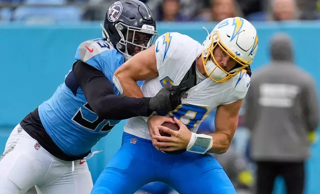 Los Angeles Chargers quarterback Justin Herbert (10) is sacked by Tennessee Titans linebacker Jihad Ward (53) during the second half of an NFL football game Sunday, Nov. 2, 2025, in Nashville, Tenn. (AP Photo/George Walker IV)