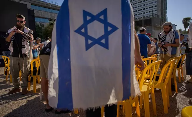 People attend a tefillin-laying ceremony led by freed hostage Bar Kupershtein, an Israeli recently released from Hamas captivity in Gaza, at a plaza known as Hostages Square, in Tel Aviv, Israel, Friday, Oct. 31, 2025. (AP Photo/Oded Balilty)