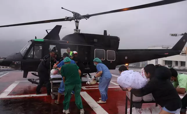 In this photo provided by the Royal Thai Army, people help patients evacuate via helicopter from a flooding area to Hat Yai Hospital in Songkhla province, southern Thailand, Wednesday, Nov. 26, 2025. (Royal Thai Army via AP)
