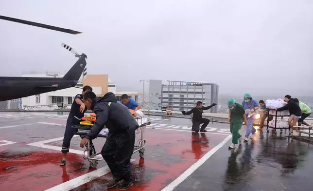 In this photo provided by the Royal Thai Army, people help patients evacuate via helicopter from a flooding area to Hat Yai Hospital in Songkhla province, southern Thailand, Wednesday, Nov. 26, 2025. (AP Photo/Royal Thai Army via AP)