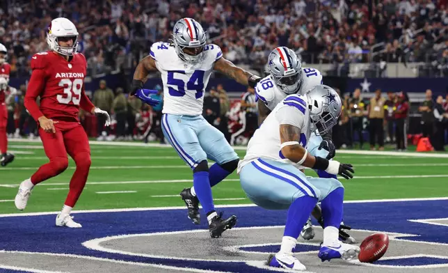 Dallas Cowboys defensive end Marshawn Kneeland, right, recovers a blocked punt for a touchdown as Sam Williams (54), Damone Clark (18) and Arizona Cardinals punter Pat O'Donnell (39) look on in the first half of an NFL football game Monday, Nov. 3, 2025, in Arlington, Texas. (AP Photo/Richard Rodriguez)