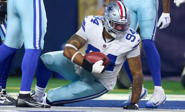 Dallas Cowboys defensive end Marshawn Kneeland (94) holds the football after recovering an Arizona Cardinals blocked bunt for a touchdown during an NFL football game between the Dallas Cowboys and the Arizona Cardinals Monday, Nov. 3, 2025, in Arlington, Texas. (AP Photo/Julio Cortez)