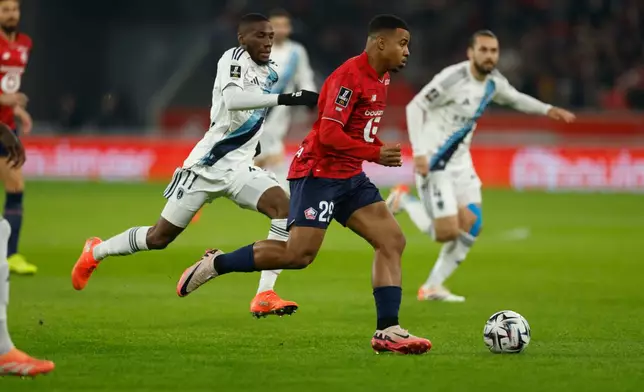 Lille's Igamane Hamza, front, plays the ball during the French League One soccer match between Lille and Paris FC in Lille, France, Sunday Nov. 23, 2025. (AP Photo/Jean-Francois Badias)