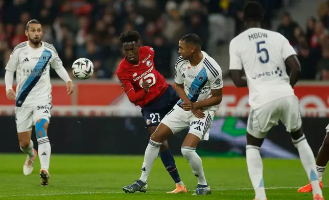 Lille's Felix Correia, center left, plays the ball during the French League One soccer match between Lille and Paris FC in Lille, France, Sunday Nov. 23, 2025. (AP Photo/Jean-Francois Badias)