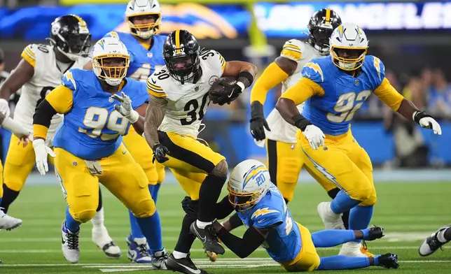 Pittsburgh Steelers running back Jaylen Warren (30) is grabbed by Los Angeles Chargers cornerback Cam Hart (20) during the first half of an NFL football game Sunday, Nov. 9, 2025, in Inglewood, Calif. (AP Photo/Marcio Jose Sanchez)