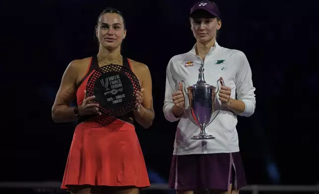 Elena Rybakina of Kazakhstan, right, holds her trophy poses with runner up Aryna Sabalenka of Belarus during the awards ceremony for the women's singles final match of the WTA finals in Riyadh, Saudi Arabia, Saturday, Nov. 8, 2025. (AP Photo/ Fatima Shbair)