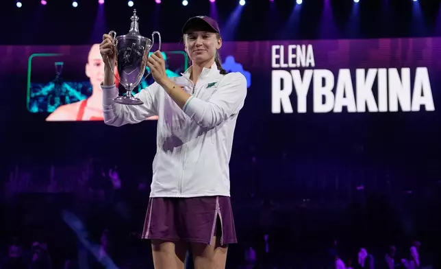 Elena Rybakina of Kazakhstan poses with the trophy after defeating Aryna Sabalenka of Belarus in the women's final singles match of the WTA finals in Riyadh, Saudi Arabia, Saturday, Nov. 8, 2025. (AP Photo/ Fatima Shbair)