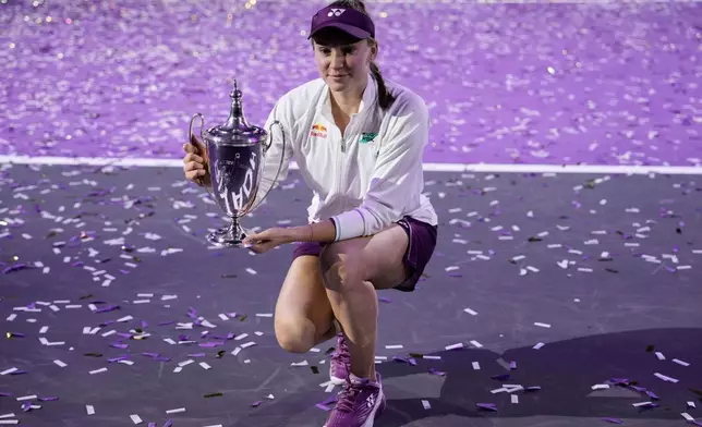 Elena Rybakina of Kazakhstan poses with the trophy after defeating Aryna Sabalenka of Belarus in the women's final singles match of the WTA finals in Riyadh, Saudi Arabia, Saturday, Nov. 8, 2025. (AP Photo/ Fatima Shbair)