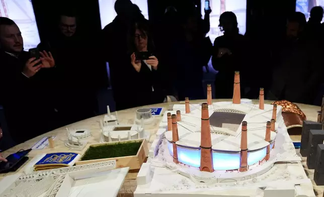 Pepole take pictures of a Diorama of Birmingham City Football Club's new stadium plans during the unveiling in Birmingham, England, Thursday, Nov. 20, 2025. (Jacob King/PA via AP)