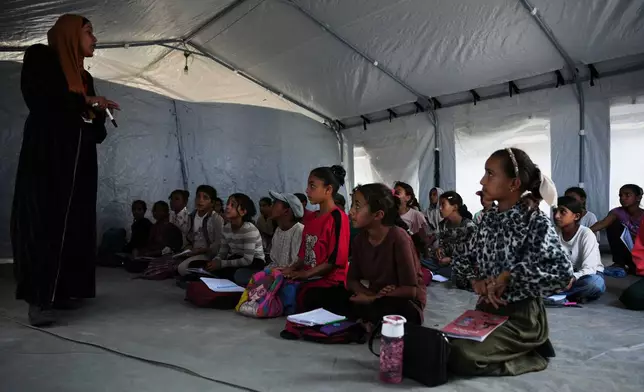 Palestinian students attend class inside a tent set up on the beach in Khan Younis, Gaza Strip, Wednesday, Nov. 12, 2025. (AP Photo/Abdel Kareem Hana)