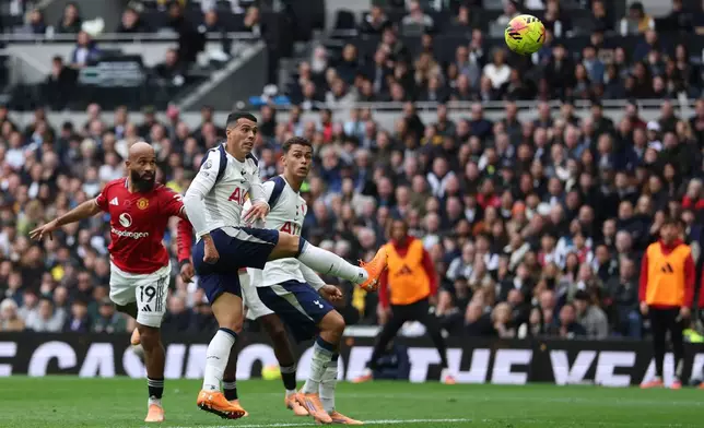 Manchester United's Bryan Mbeumo, left, scores his side's opening goal during the English Premier League soccer match between Tottenham Hotspur and Manchester United in London, England, Saturday, Nov. 8, 2025. (AP Photo/Ian Walton)