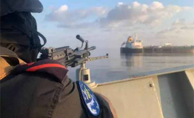 A member of the European Union's Operation Atalanta mans a machine gun aboard the ESPS Victoria while watching the Hellas Aphrodite off the coast of Somalia in the Arabian Sea on Friday, Nov. 7, 2025. (European Union's Operation Atalanta via AP)