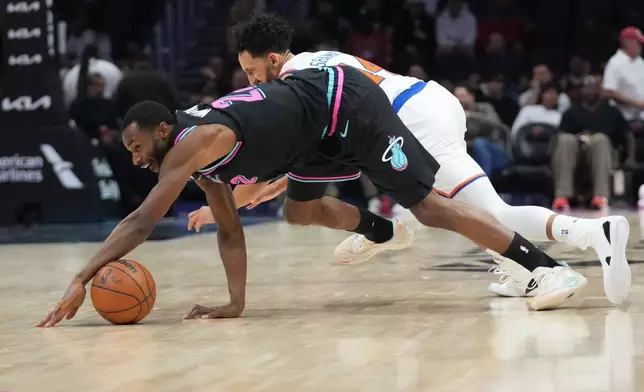 Miami Heat forward Andrew Wiggins, front goes for the ball against New York Knicks guard Landry Shamet during the second half of an NBA basketball game, Monday, Nov. 17, 2025, in Miami. (AP Photo/Lynne Sladky)