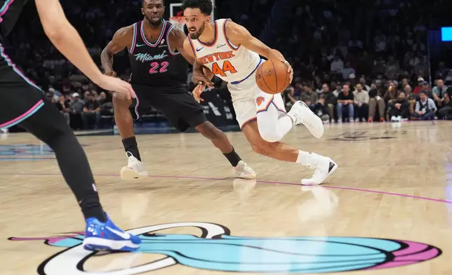 New York Knicks guard Landry Shamet (44) drives to the basket as Miami Heat forward Andrew Wiggins (22) defends during the first half of an NBA basketball game, Monday, Nov. 17, 2025, in Miami. (AP Photo/Lynne Sladky)